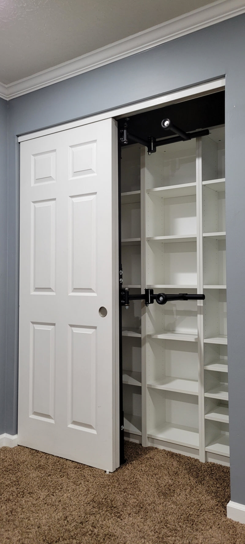 Clever rotating closet rod in front of shelving in a empty close nifty closet organizer 